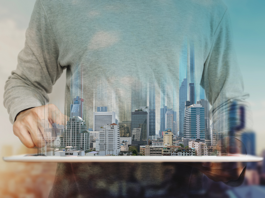 Um homem usando tablet digital e holograma de edifícios modernos. Negócios imobiliários e conceito de tecnologia de construção.